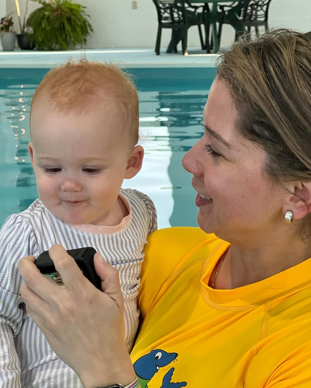Cynthia holding a baby in the pool
